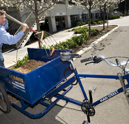 Michael Griffith of the grounds crew is pictured with a new bicycle cart that he is using instead of a motor-powered cart.